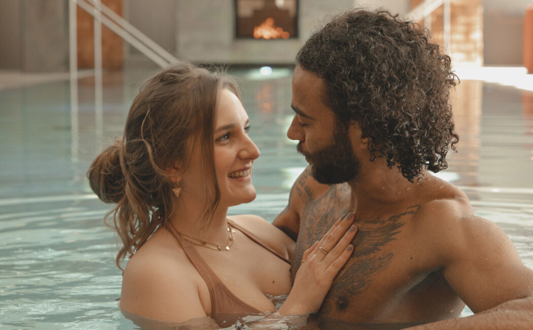Pärchen im Pool genießt eine romantische Auszeit beim Wellness für Paare im Wellnesshotel im Berchtesgadener Land